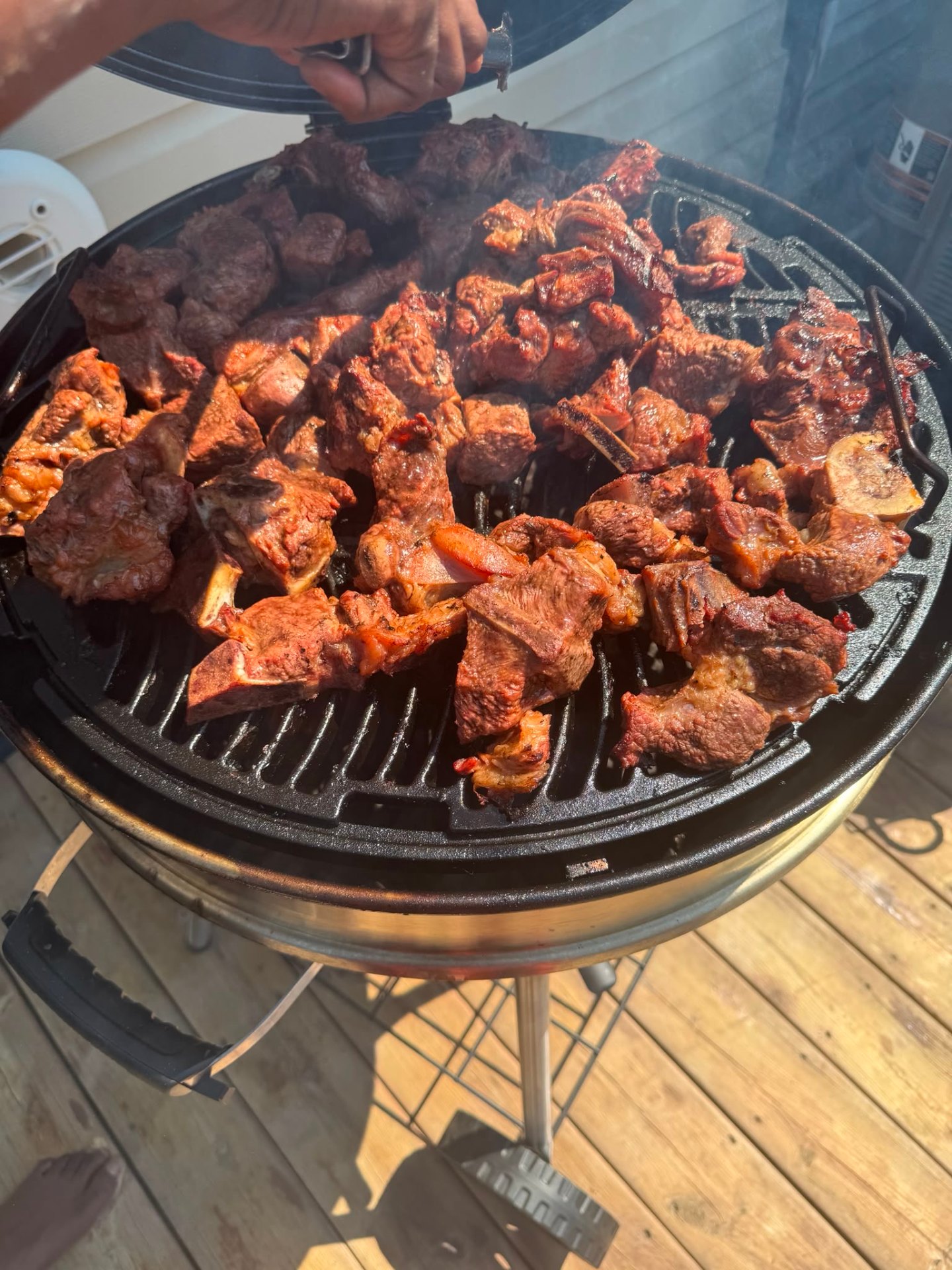The Executive Chef grilling seasoned goat and beef over hardwood charcoal